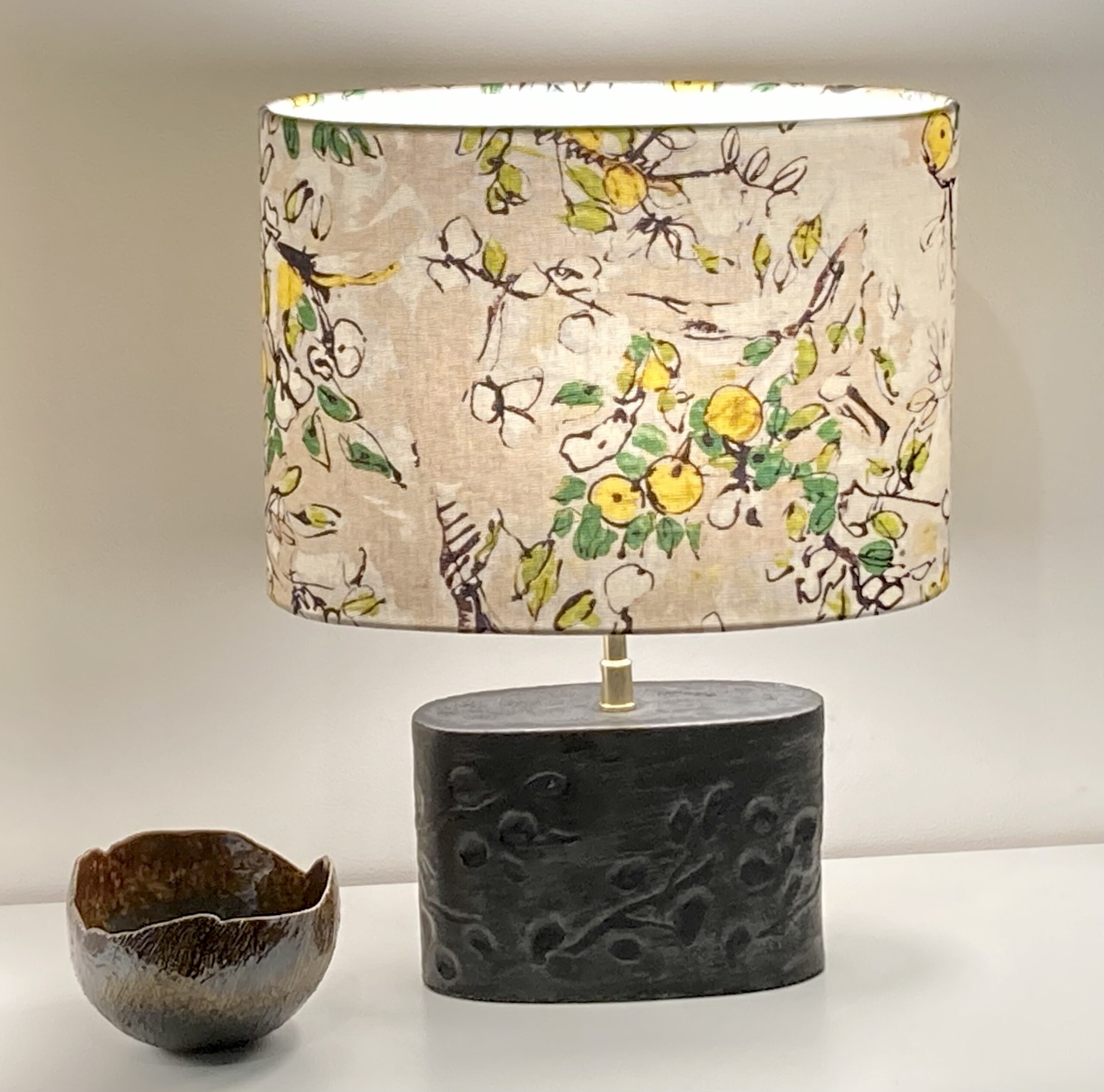 Sigi créations, Lampe au pied en gré anthracite avec un abat-jour ovale couleur lin et motif fleurie jaune. 
